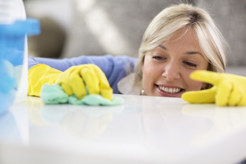 Cleaner wearing PPE while handling cleaning products in a property